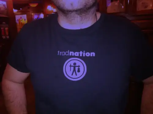 Tshirt noir avec logo Tradnation, texte avec icône bonhomme avec violon et archet, blanc sur violet