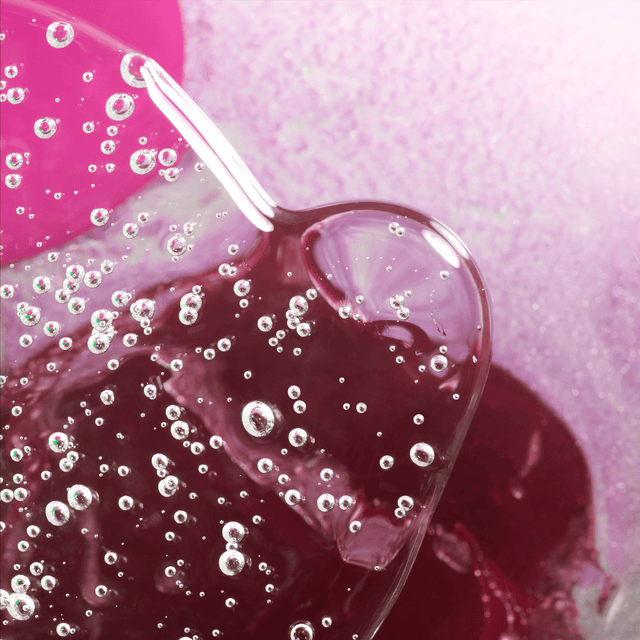 Magenta photo of glass blobs with tiny bubbles rising through them